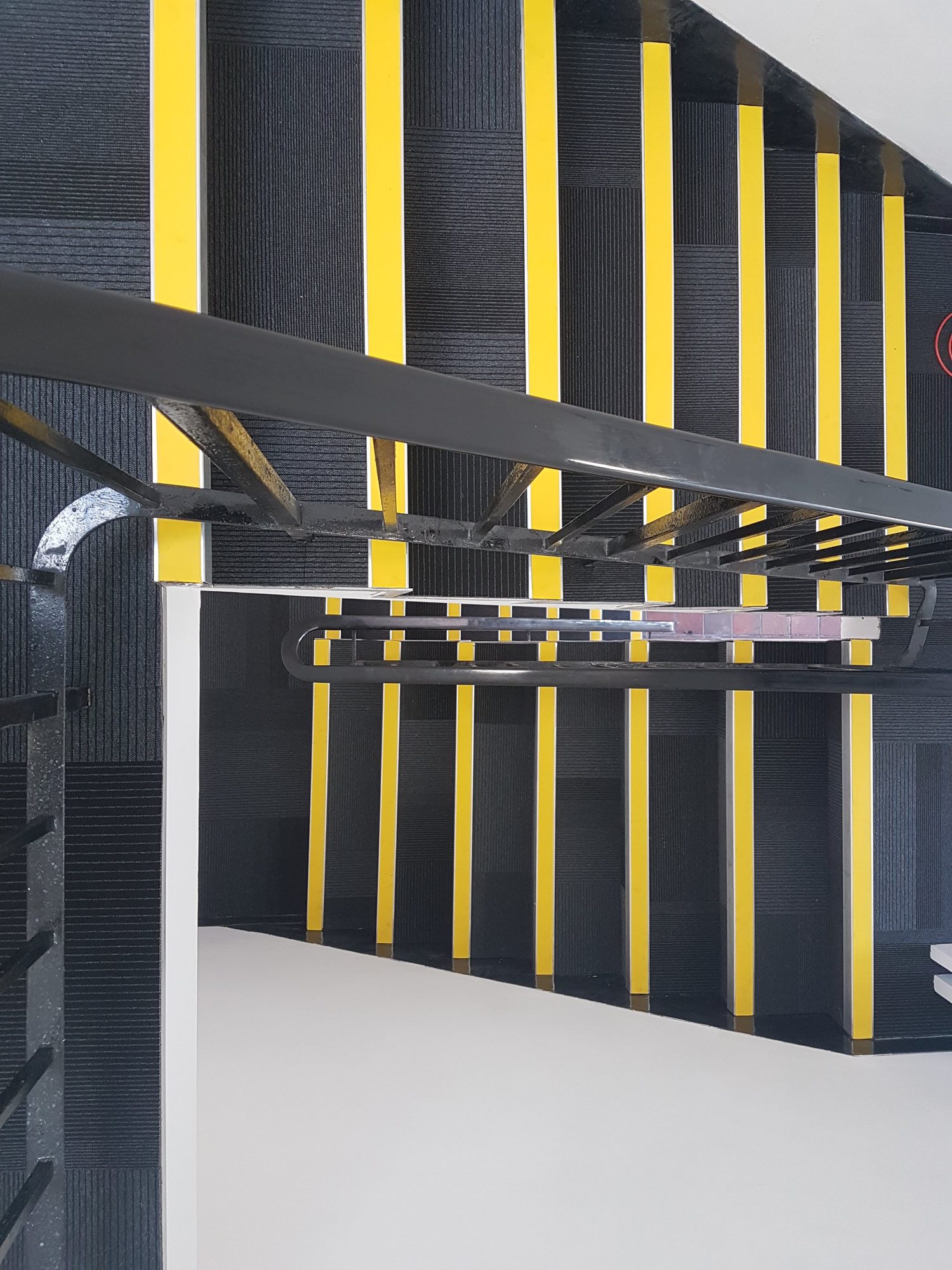 Dark commercial stair flooring with bright yellow tread-edge strips
