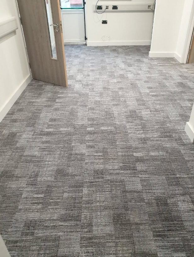 Grey patterned commercial carpet tiles in an office room