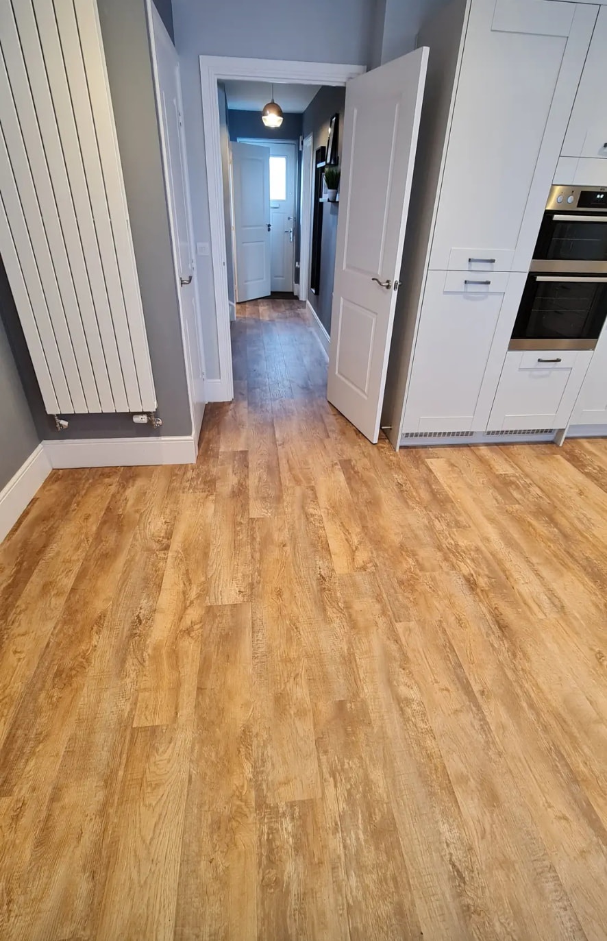 Wood-effect plank flooring through a kitchen and hallway