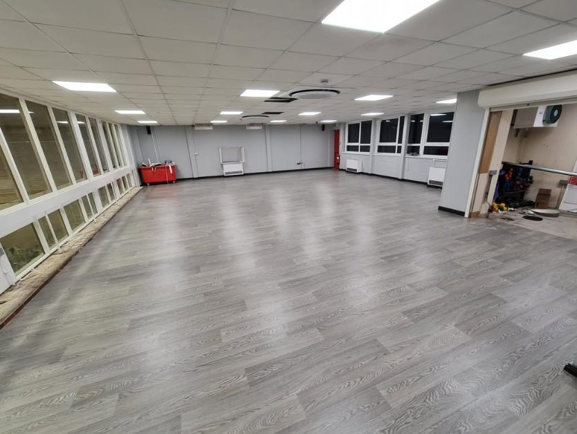 Grey wood-effect commercial flooring in a large room