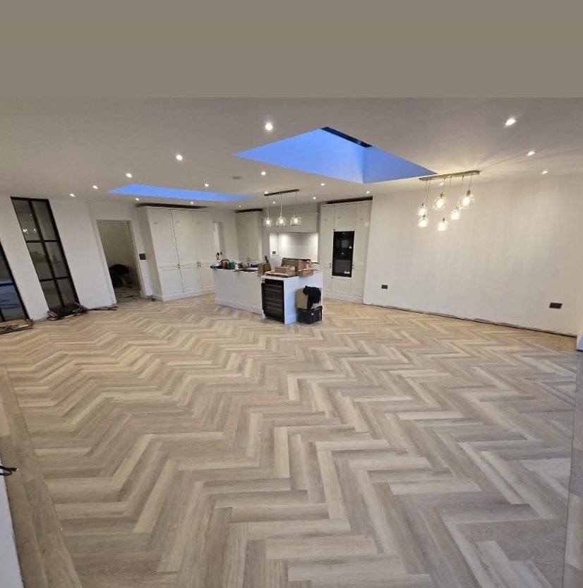 Herringbone-pattern floor across an open-plan refurbishment