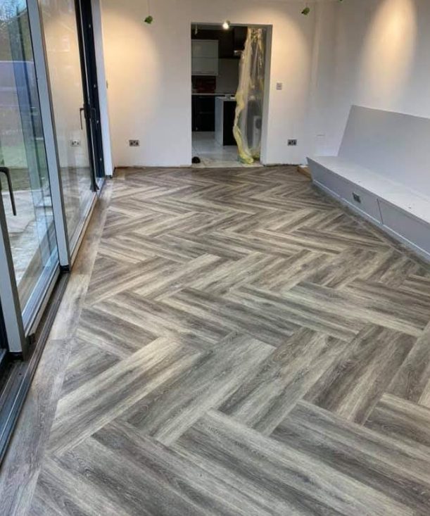 Grey herringbone-pattern floor fitted through a glazed doorway