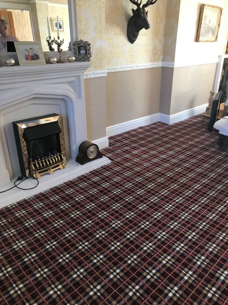 Red tartan carpet fitted across a living room