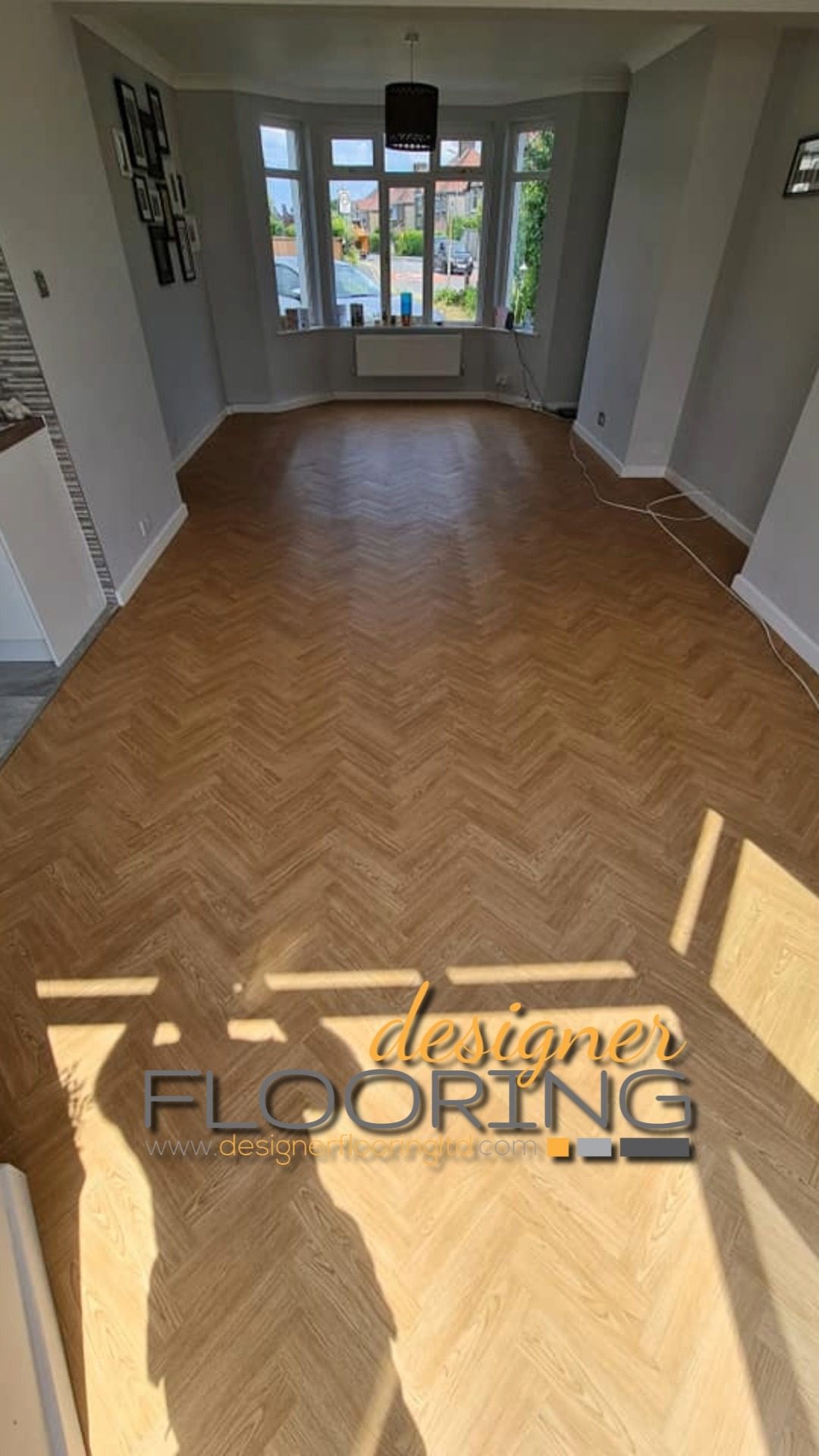 Wood-tone herringbone flooring in a sunlit room