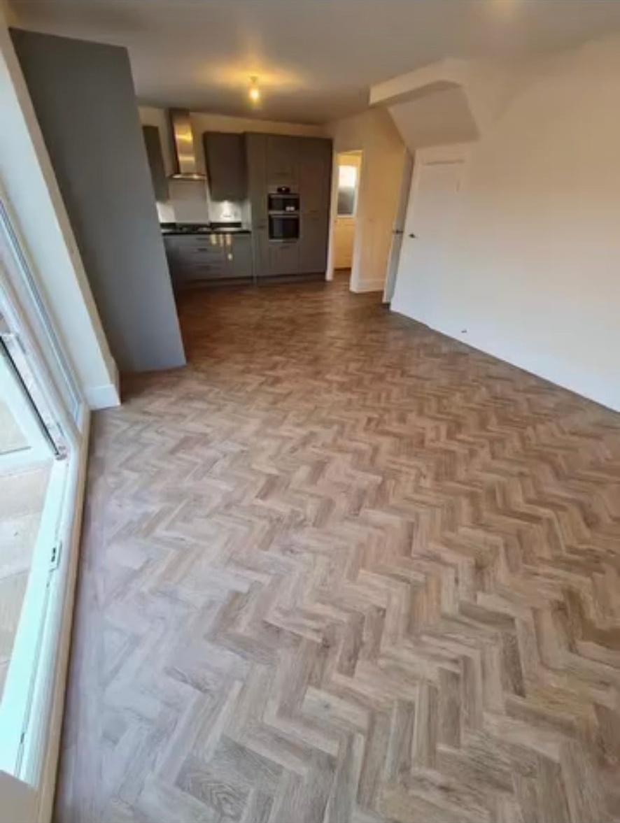 Herringbone flooring across an open-plan kitchen