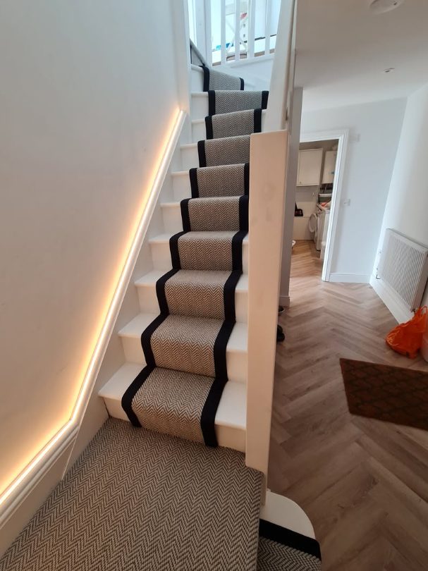 Carpet stair runner with contrasting dark borders and landing carpet