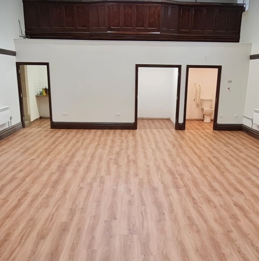 Wood-effect plank flooring across a large hall