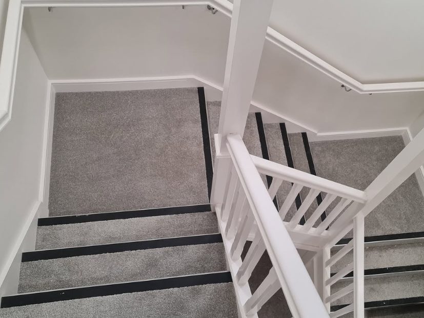 Grey stair carpet fitted with dark contrasting edge strips