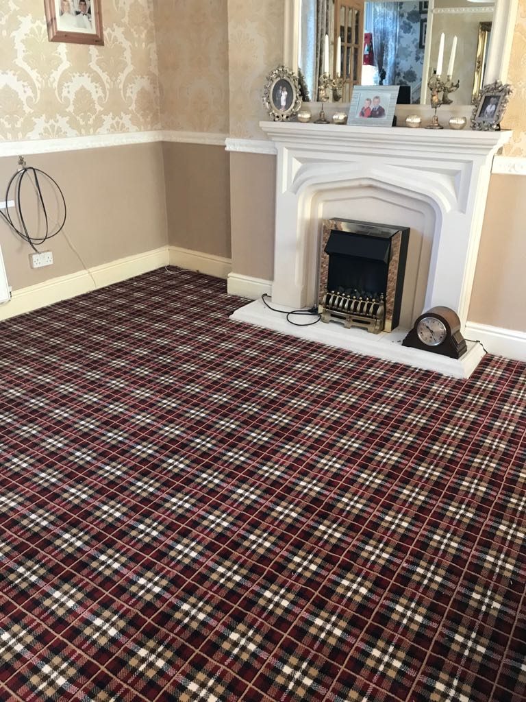 Red tartan living-room carpet fitted beside a fireplace
