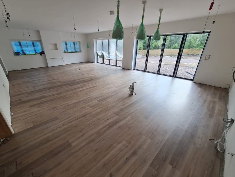 Wood-effect plank flooring across an open-plan room during refurbishment