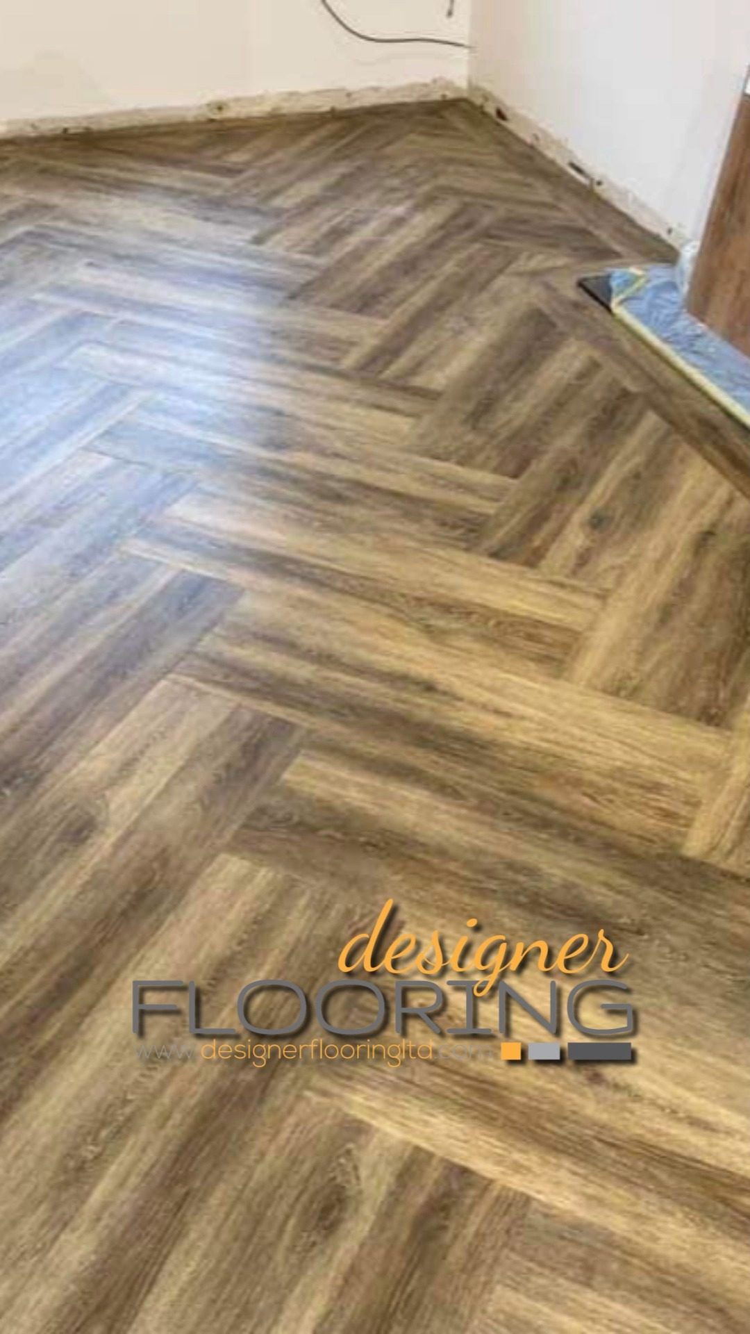 Close view of herringbone flooring with visible wood grain and neat edge finishing